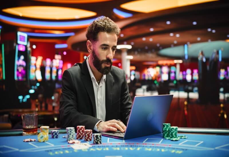 A person is using a laptop for sports betting in Black Hawk, CO & Denver Metro